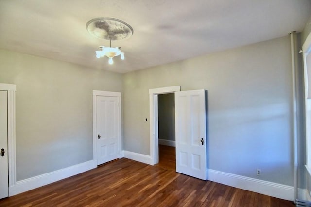 15-1/2 Tremlett St, Boston, MA 02124 - unfurnished bedroom featuring dark wood-type flooring, baseboards, and a chandelier