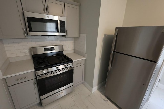 15-1/2 Tremlett St, Boston, MA 02124 - kitchen featuring stainless steel appliances, gray cabinetry, light marble finish flooring, light countertops, and decorative backsplash