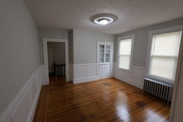 15-1/2 Tremlett St, Boston, MA 02124 - unfurnished room featuring radiator heating unit, wood finished floors, a decorative wall, and a wainscoted wall