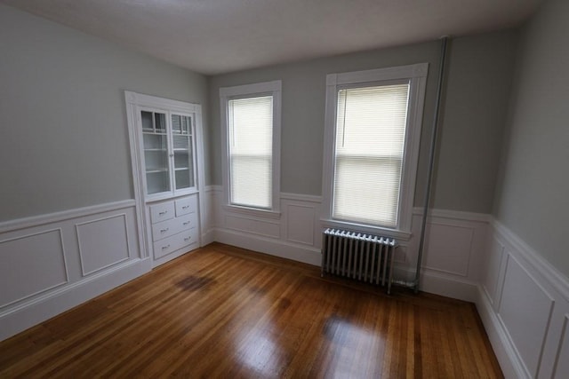 15-1/2 Tremlett St, Boston, MA 02124 - spare room featuring radiator, wood finished floors, wainscoting, and a decorative wall