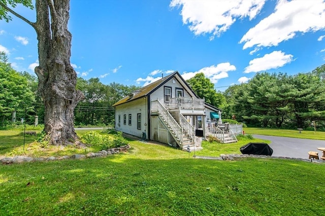 67 Main St, Atkinson, NH 03811 - back of house featuring stairway, a wooden deck, and a lawn