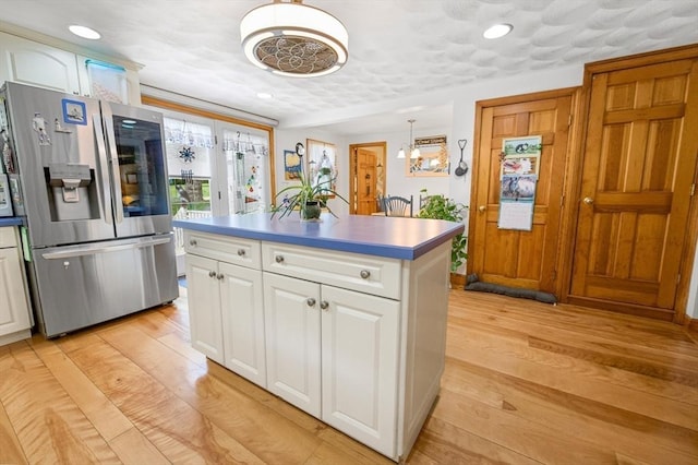 67 Main St, Atkinson, NH 03811 - kitchen featuring stainless steel fridge with ice dispenser, white cabinetry, a center island, light wood finished floors, and recessed lighting