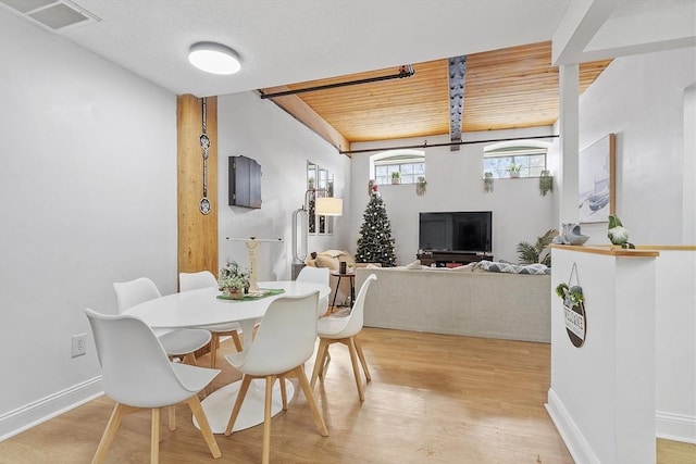 dining area with light wood-type flooring and wood ceiling