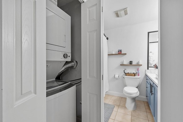 bathroom with vanity, stacked washer / drying machine, tile patterned floors, and toilet