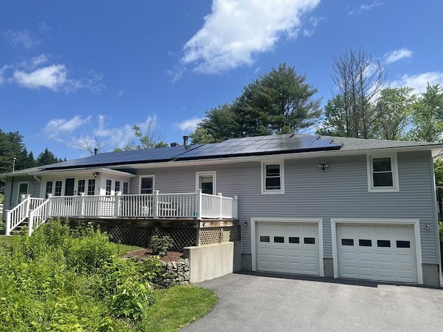 156 Langen Rd, Lancaster, MA 01523 - ranch-style home featuring an attached garage, asphalt driveway, a wooden deck, and solar panels