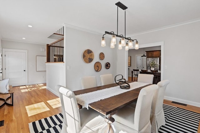 dining room with recessed lighting, light wood-type flooring, baseboards, and ornamental molding