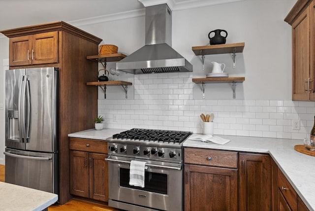 kitchen with tasteful backsplash, light countertops, stainless steel appliances, wall chimney exhaust hood, and open shelves