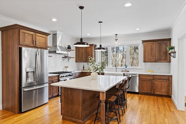 kitchen with ventilation hood, light wood-style floors, appliances with stainless steel finishes, and crown molding