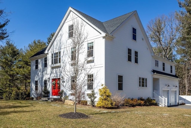 view of front of property with a garage, board and batten siding, driveway, and a front lawn