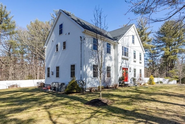 exterior space featuring entry steps, central AC, a front lawn, and fence