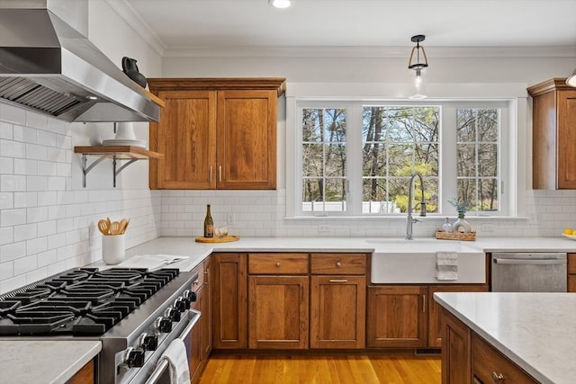 kitchen featuring brown cabinetry, ornamental molding, stainless steel appliances, and exhaust hood