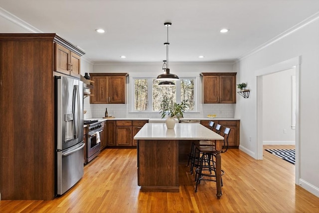 kitchen featuring light countertops, a kitchen breakfast bar, light wood-style flooring, and stainless steel appliances