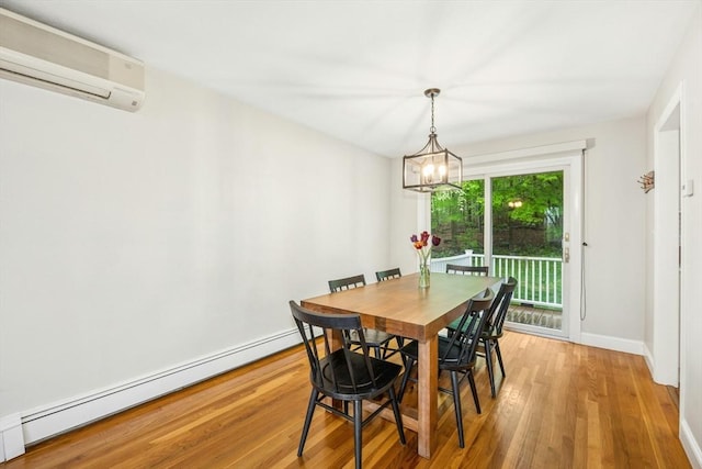 dining area featuring a baseboard radiator, an AC wall unit, baseboards, a chandelier, and wood finished floors