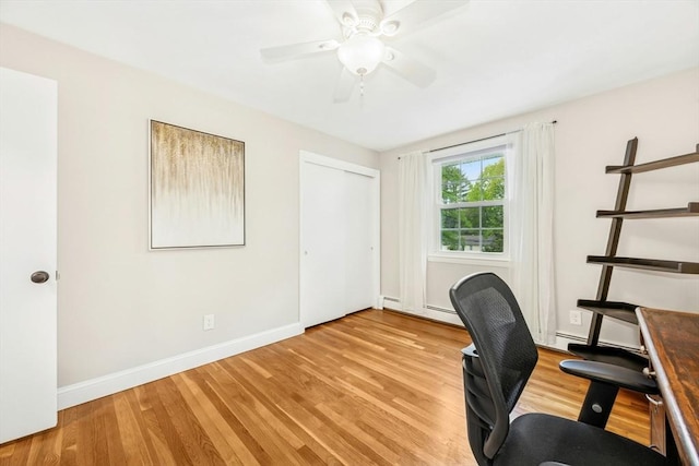 unfurnished office featuring baseboards, light wood-style floors, and ceiling fan
