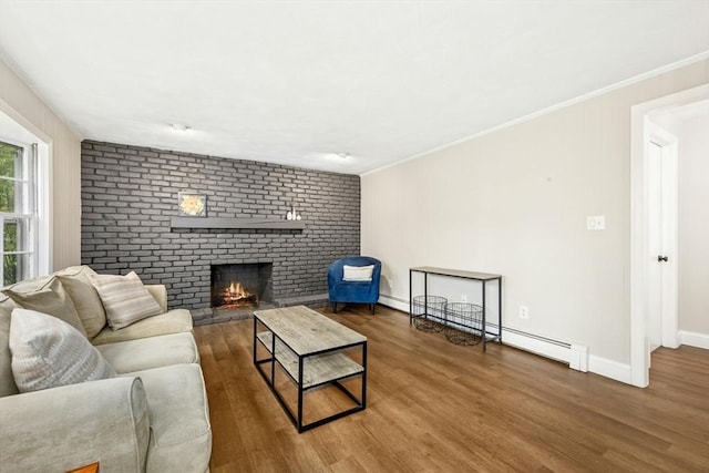 living room with a fireplace, crown molding, baseboards, and wood finished floors