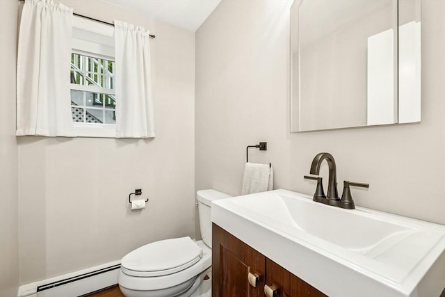 half bathroom with toilet, baseboard heating, and vanity
