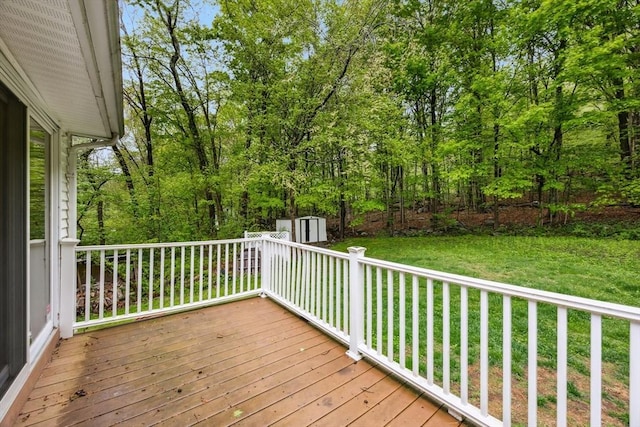 wooden deck featuring a yard, a storage shed, and an outdoor structure