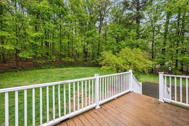 wooden terrace featuring a lawn