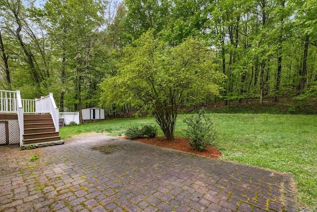 view of patio with an outdoor structure, stairway, a deck, and a shed