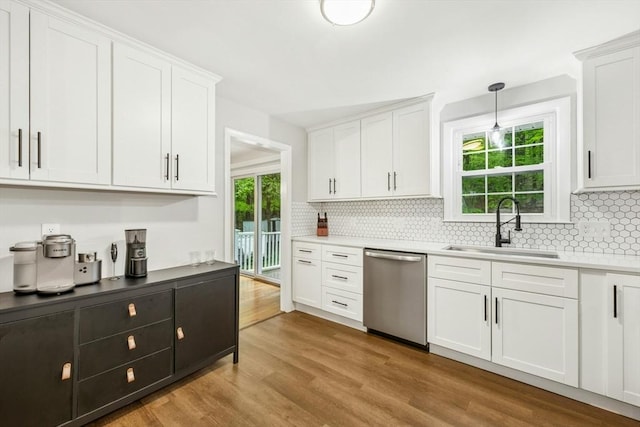 kitchen with white cabinetry, a sink, stainless steel dishwasher, and tasteful backsplash