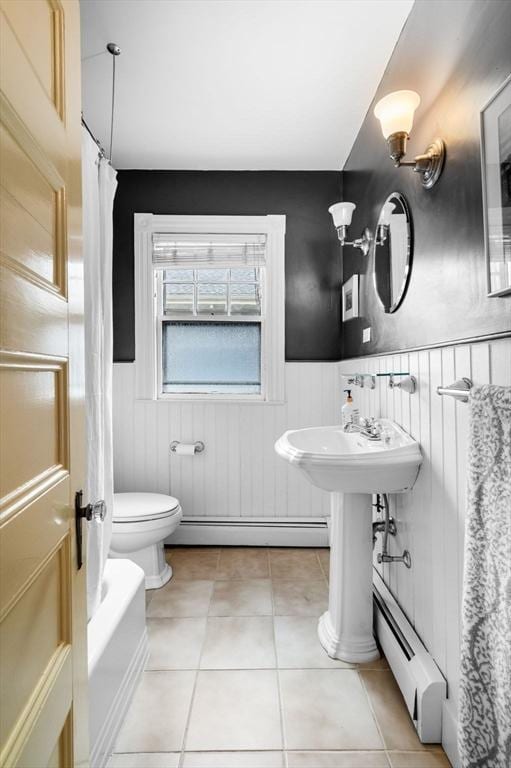 full bathroom featuring baseboard heating, wainscoting, tile patterned flooring, and toilet