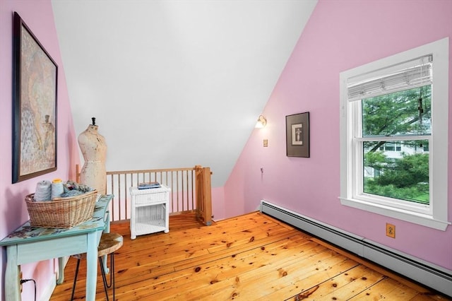 additional living space featuring baseboard heating, vaulted ceiling, and hardwood / wood-style floors