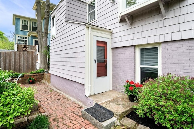 view of exterior entry featuring fence