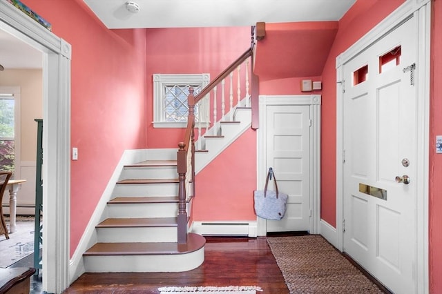 foyer entrance featuring a baseboard heating unit, stairs, wood finished floors, and baseboards