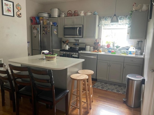 108 Grove St, Lynn, MA 01905 - kitchen featuring stainless steel appliances, gray cabinets, and a kitchen breakfast bar