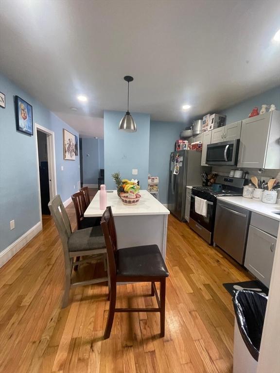 108 Grove St, Lynn, MA 01905 - kitchen with appliances with stainless steel finishes, light wood-style flooring, light countertops, hanging light fixtures, and recessed lighting