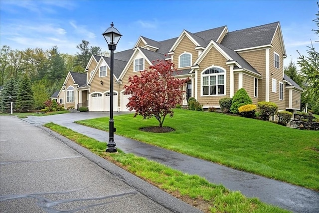 traditional home featuring a front yard, a garage, and driveway
