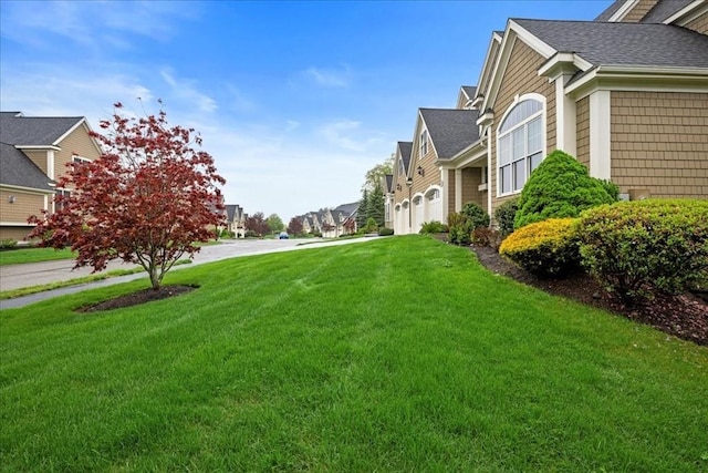 view of yard with a residential view and a garage