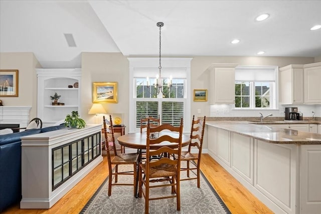 dining area with recessed lighting, an inviting chandelier, visible vents, vaulted ceiling, and light wood-style floors