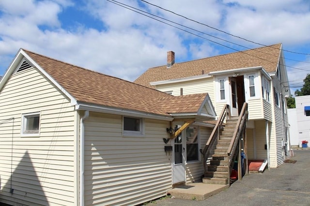 28-30 W Main St, Ware, MA 01082 - rear view of property featuring a shingled roof, stairway, and a chimney