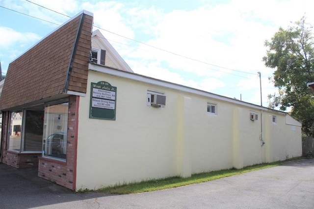 28-30 W Main St, Ware, MA 01082 - view of property exterior featuring roof with shingles, brick siding, and stucco siding