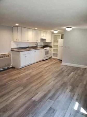 28-30 W Main St, Ware, MA 01082 - kitchen featuring white appliances, wood finished floors, dark countertops, recessed lighting, and white cabinets