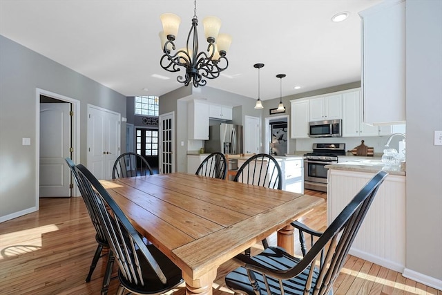 dining area with an inviting chandelier, light wood-style flooring, baseboards, and recessed lighting