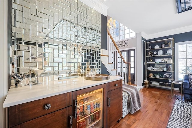 bar with dark wood-style floors, wine cooler, stairway, and crown molding