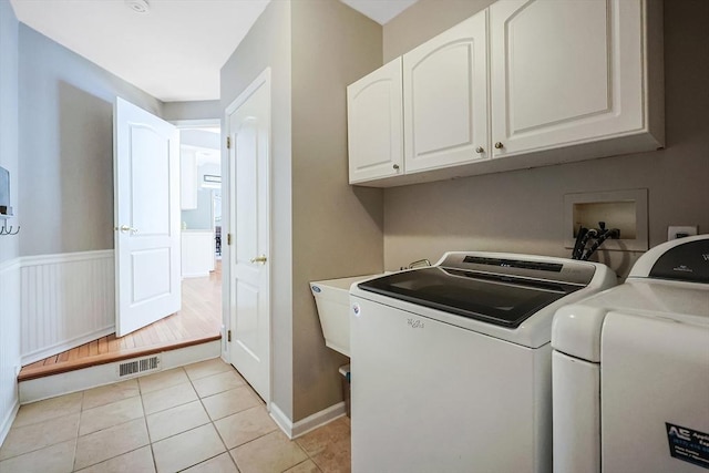 washroom with cabinet space, light tile patterned floors, visible vents, and independent washer and dryer