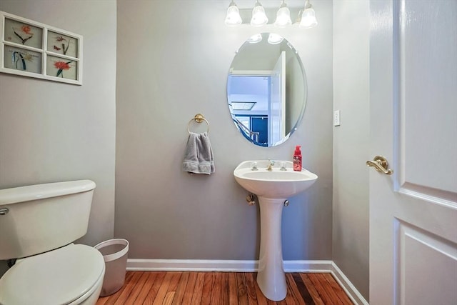 bathroom featuring toilet, baseboards, and wood finished floors