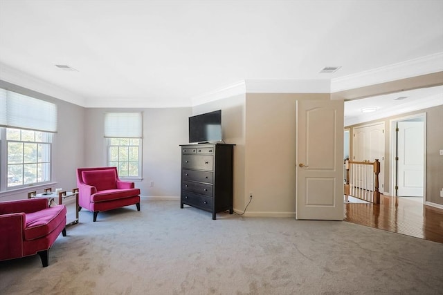 living area with ornamental molding, light colored carpet, and visible vents