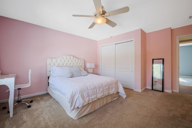 bedroom featuring a ceiling fan, baseboards, a closet, and light colored carpet