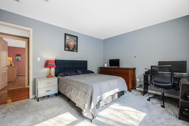 bedroom featuring light carpet and baseboards