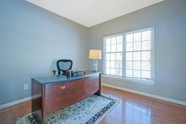 office featuring light wood-style floors, visible vents, and baseboards