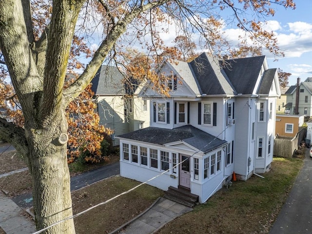 view of front of property featuring a front yard and a sunroom