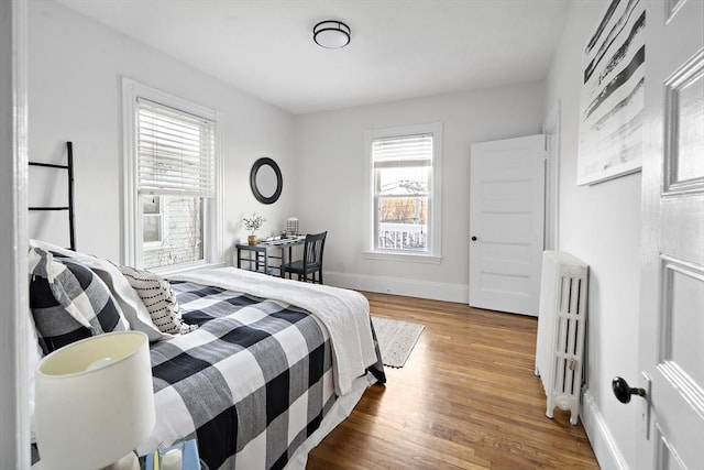 bedroom featuring wood-type flooring and radiator heating unit