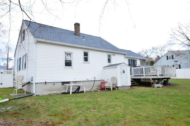 24 Dorothy Ave, Dracut, MA 01826 - back of property featuring a chimney, a wooden deck, a storage shed, and a shingled roof