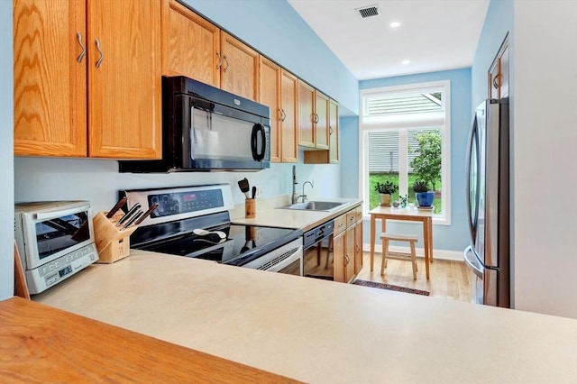 14 Michaels Grn Unit 14, Woburn, MA 01801 - kitchen featuring black appliances, a sink, light countertops, light wood-style floors, and recessed lighting