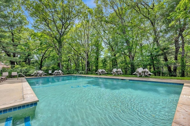 14 Michaels Grn Unit 14, Woburn, MA 01801 - community pool with a fenced backyard, view of wooded area, and a patio area