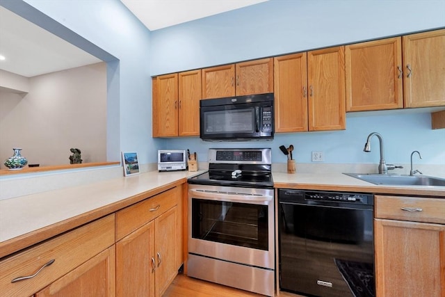 14 Michaels Grn Unit 14, Woburn, MA 01801 - kitchen featuring black appliances, a sink, light countertops, and brown cabinetry